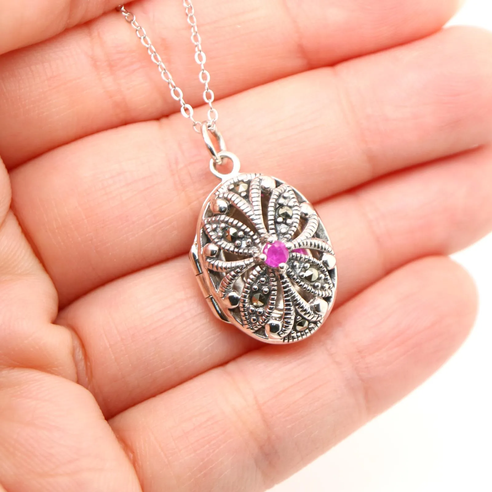 Flower locket in sterling silver with ruby and marcasite